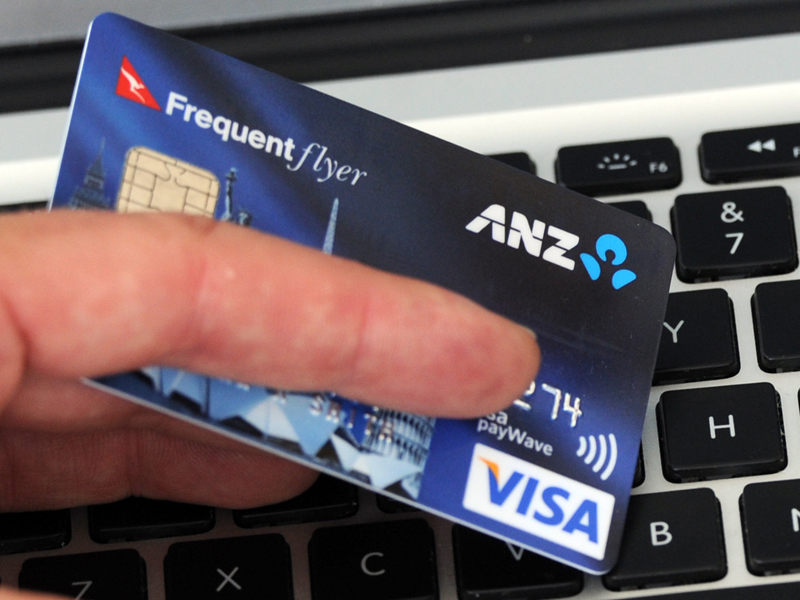 A credit card is held in front an online shopping site in Melbourne, Friday, Sept. 20, 2013. (AAP Image/Julian Smith) NO ARCHIVING